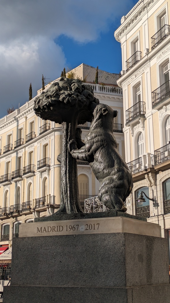 The bronze statue of the a bear leaning against a madrono tree in Madrid's Sol square